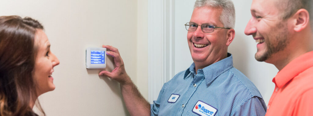 Baggett Heating and Cooling employee with thermostat - Clarksville HVAC company
